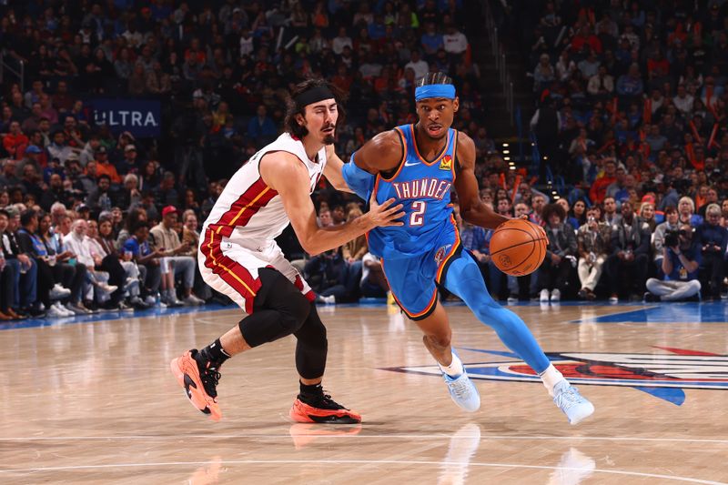 OKLAHOMA CITY, OK - MARCH 8:  Shai Gilgeous-Alexander #2 of the Oklahoma City Thunder handles the ball during the game as Jaime Jaquez Jr. #11 of the Miami Heat plays defense on March 8, 2024 at Paycom Arena in Oklahoma City, Oklahoma. NOTE TO USER: User expressly acknowledges and agrees that, by downloading and or using this photograph, User is consenting to the terms and conditions of the Getty Images License Agreement. Mandatory Copyright Notice: Copyright 2024 NBAE (Photo by Zach Beeker/NBAE via Getty Images)