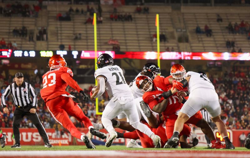 Nov 11, 2023; Houston, Texas, USA; Cincinnati Bearcats running back Corey Kiner (21) rushes past Houston Cougars defensive back Isaiah Hamilton (23) for a first down  in the first half at TDECU Stadium. Mandatory Credit: Thomas Shea-USA TODAY Sports