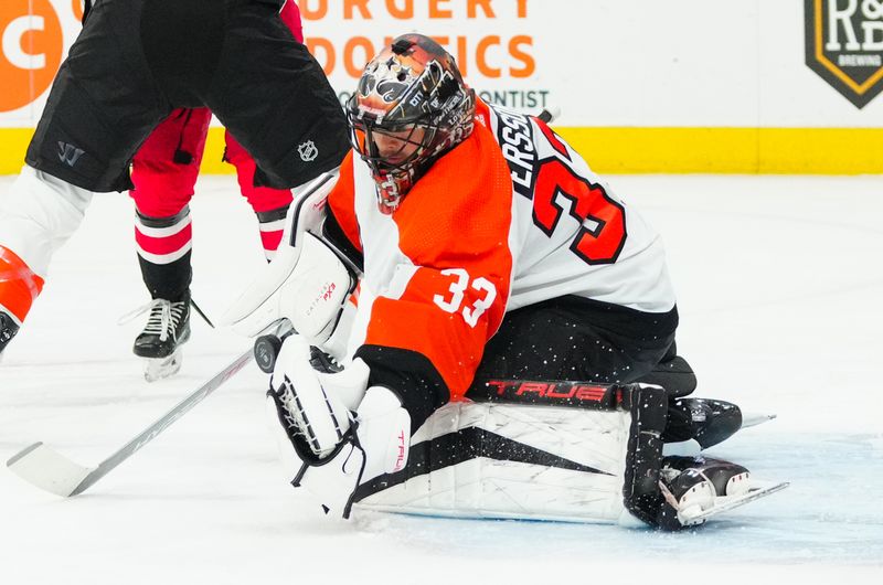 Mar 21, 2024; Raleigh, North Carolina, USA; Philadelphia Flyers goaltender Samuel Ersson (33) reaches out with the glove to make a save against the Carolina Hurricanes during the first period at PNC Arena. Mandatory Credit: James Guillory-USA TODAY Sports