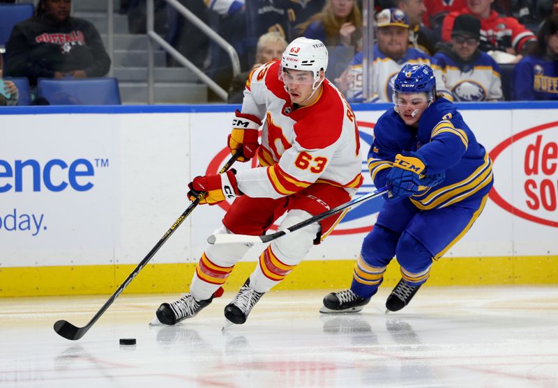 Oct 19, 2023; Buffalo, New York, USA;  Calgary Flames center Adam Ruzicka (63) skates with the puck as Buffalo Sabres left wing Zach Benson (9) defends during the second period at KeyBank Center. Mandatory Credit: Timothy T. Ludwig-USA TODAY Sports