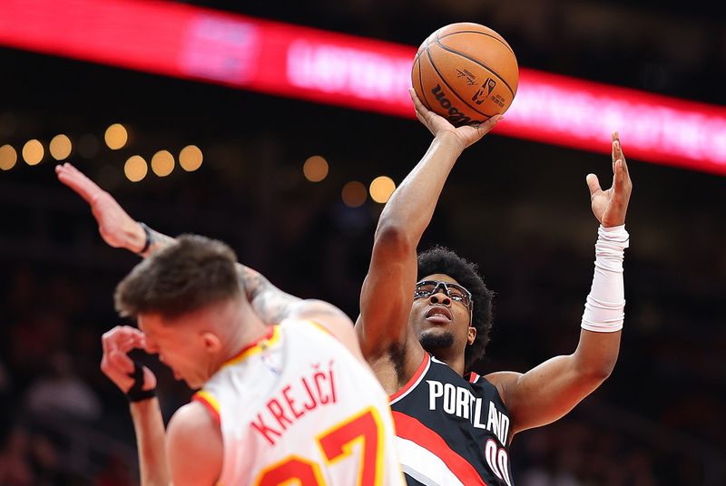 ATLANTA, GEORGIA - MARCH 27:  Scoot Henderson #00 of the Portland Trail Blazers is charged with an offensive foul as he drives into Vit Krejci #27 of the Atlanta Hawks during the first quarter at State Farm Arena on March 27, 2024 in Atlanta, Georgia.  NOTE TO USER: User expressly acknowledges and agrees that, by downloading and/or using this photograph, user is consenting to the terms and conditions of the Getty Images License Agreement.  (Photo by Kevin C. Cox/Getty Images)