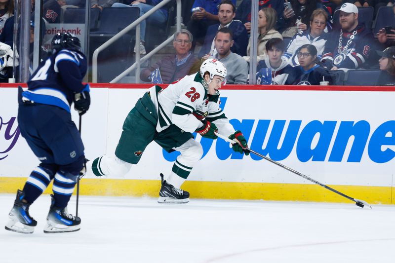 Oct 13, 2024; Winnipeg, Manitoba, CAN;  Minnesota Wild forward Liam Ohgren (28) skates away from Winnipeg Jets defenseman Josh Morrissey (44) during the first period at Canada Life Centre. Mandatory Credit: Terrence Lee-Imagn Images