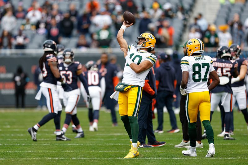 Green Bay Packers quarterback Jordan Love (10) greets running back Emanuel Wilson (31) during warm ups before an NFL football game against the Chicago Bears, Sunday, Nov. 17, 2024, in Chicago. (AP Photo/Kamil Krzaczynski)