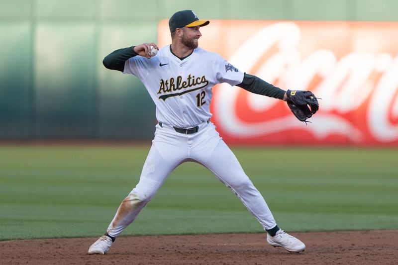 Aug 6, 2024; Oakland, California, USA;  Oakland Athletics shortstop Max Schuemann (12) throws the ball during the third inning against the Chicago White Sox at Oakland-Alameda County Coliseum. Mandatory Credit: Stan Szeto-USA TODAY Sports