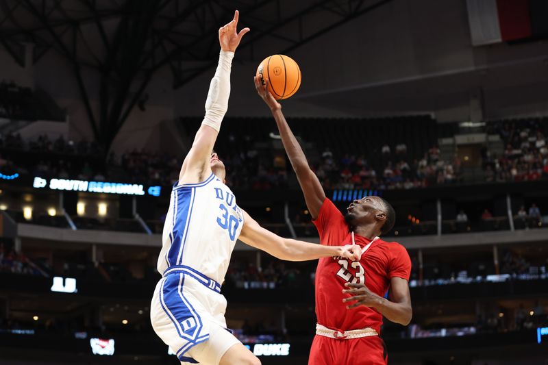 Mar 31, 2024; Dallas, TX, USA; North Carolina State Wolfpack forward Mohamed Diarra (23) shoots against Duke Blue Devils center Kyle Filipowski (30) in the first half in the finals of the South Regional of the 2024 NCAA Tournament at American Airline Center. Mandatory Credit: Tim Heitman-USA TODAY Sports