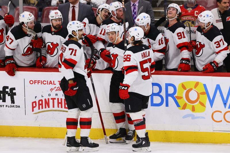 Nov 14, 2024; Sunrise, Florida, USA; New Jersey Devils left wing Jesper Bratt (63) celebrates with defenseman Jonas Siegenthaler (71) and left wing Erik Haula (56) after scoring against the Florida Panthers during the third period at Amerant Bank Arena. Mandatory Credit: Sam Navarro-Imagn Images