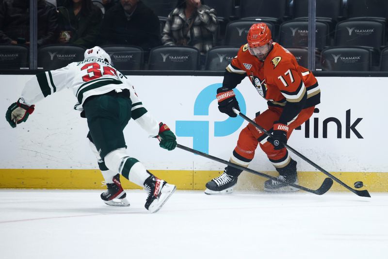 Nov 8, 2024; Anaheim, California, USA; Anaheim Ducks left wing Alex Killorn (17) skates with the puck against Minnesota Wild right wing Mats Zuccarello (36) during the first period of a hockey game at Honda Center. Mandatory Credit: Jessica Alcheh-Imagn Images