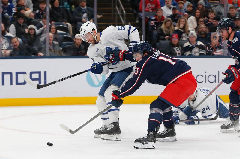 Nov 26, 2025; Columbus, Ohio, USA; Toronto Maple Leafs center Nicolas Roy (55) wrists a shot on goal as Columbus Blue Jackets defenseman Dante Fabbro (15) defends during the first period at Nationwide Arena. Mandatory Credit: Russell LaBounty-Imagn Images
