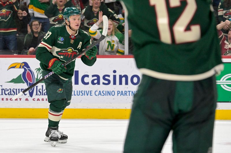 Jan 25, 2024; Saint Paul, Minnesota, USA; Minnesota Wild forward Kirill Kaprizov (97) his assist to forward Joel Eriksson Ek (14) for a goal against the Nashville Predators during the second period at Xcel Energy Center. Mandatory Credit: Nick Wosika-USA TODAY Sports