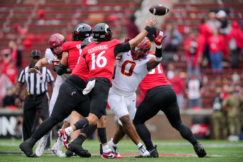 Oct 14, 2023; Cincinnati, Ohio, USA;  Cincinnati Bearcats quarterback Brady Lichtenberg (16) throws a pass as he is pressured by Iowa State Cyclones linebacker Zach Lovett (0) in the second half at Nippert Stadium. Mandatory Credit: Aaron Doster-USA TODAY Sports