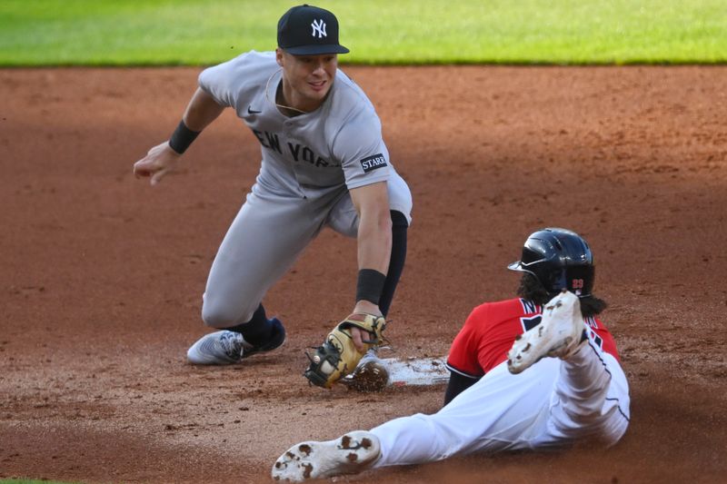 Apr 22, 2025; Cleveland, Ohio, USA; Cleveland Guardians catcher Bo Naylor (23) steals second base beside New York Yankees shortstop Anthony Volpe (11) in the second inning at Progressive Field. Mandatory Credit: David Richard-Imagn Images