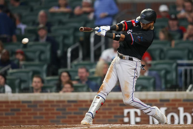 Apr 24, 2024; Atlanta, Georgia, USA; Miami Marlins first baseman Luis Arraez (3) hits single against the Atlanta Braves in the tenth inning at Truist Park. Mandatory Credit: Brett Davis-USA TODAY Sports