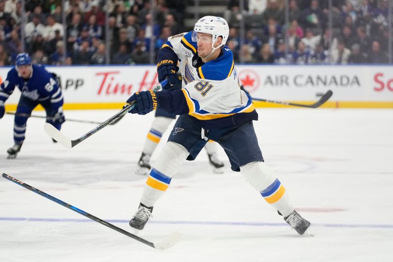 Oct 24, 2024; Toronto, Ontario, CAN; St. Louis Blues forward Dylan Holloway (81) shoots the puck against the Toronto Maple Leafs during the second period at Scotiabank Arena. Mandatory Credit: John E. Sokolowski-Imagn Images