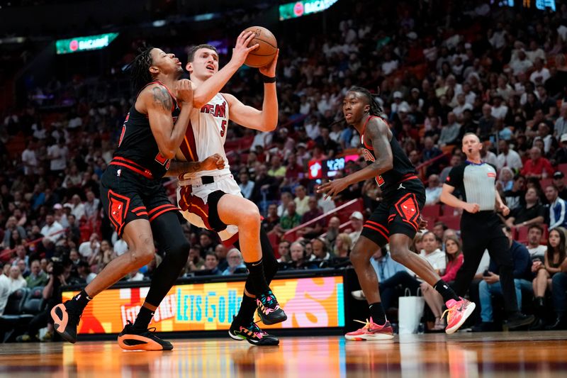 MIAMI, FLORIDA - APRIL 19: Nikola Jovic #5 of the Miami Heat drives to the basket against Dalen Terry #25 of the Chicago Bulls in the first quarter during the Play-In Tournament at Kaseya Center on April 19, 2024 in Miami, Florida. NOTE TO USER: User expressly acknowledges and agrees that, by downloading and or using this photograph, User is consenting to the terms and conditions of the Getty Images License Agreement. (Photo by Rich Storry/Getty Images)