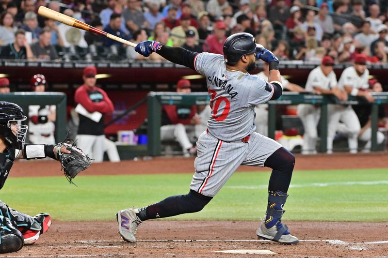 Jun 27, 2024; Phoenix, Arizona, USA;  Minnesota Twins first base Carlos Santana (30) hits an RBI double in the second inning against the Arizona Diamondbacks at Chase Field. Mandatory Credit: Matt Kartozian-USA TODAY Sports