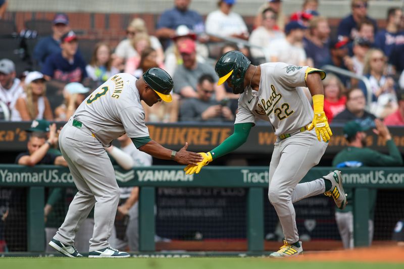 Jun 1, 2024; Atlanta, Georgia, USA; Oakland Athletics left fielder Miguel Andujar (22) celebrates with third base coach Eric Martins (3) after a three-run home run against the Atlanta Braves in the second inning at Truist Park. Mandatory Credit: Brett Davis-USA TODAY Sports