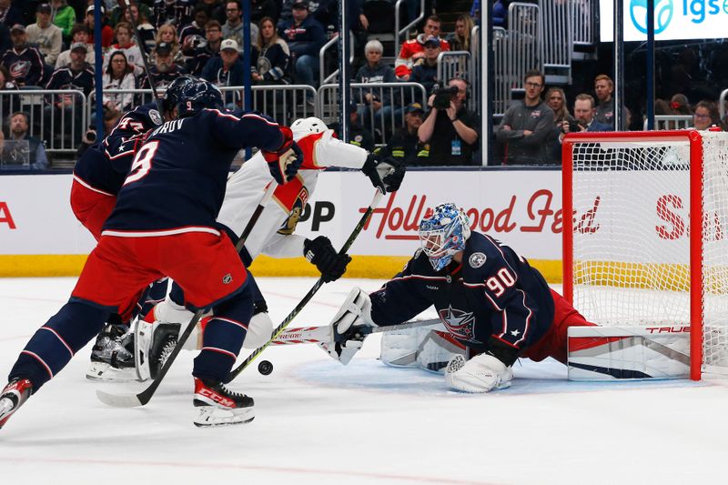 Oct 15, 2024; Columbus, Ohio, USA; Columbus Blue Jackets goalie Elvis Merzlikins (90) makes a stick save from the shot attempt of Florida Panthers center Sam Bennett (9) during the first period at Nationwide Arena. Mandatory Credit: Russell LaBounty-Imagn Images