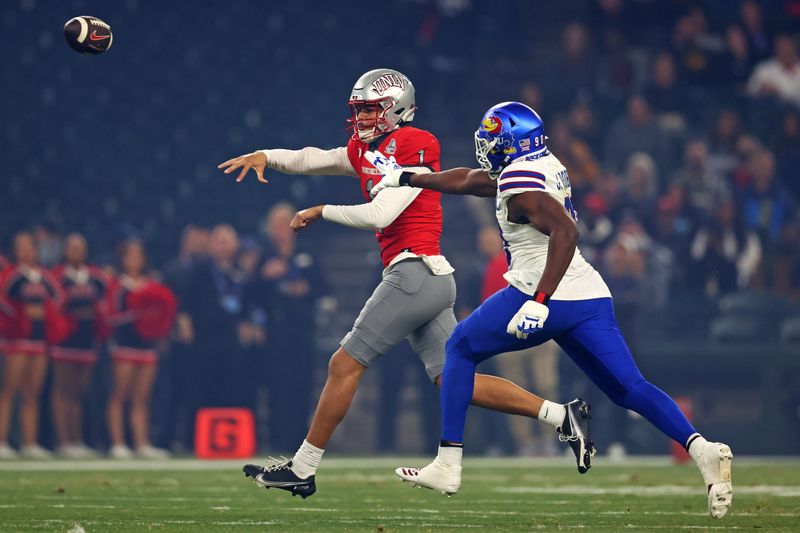 Dec 26, 2023; Phoenix, AZ, USA; UNLV Rebels quarterback Jayden Maiava (1) roles out to pass against Kansas Jayhawks defensive lineman Jereme Robinson (90) during the first quarter in the Guaranteed Rate Bowl at Chase Field. Mandatory Credit: Mark J. Rebilas-USA TODAY Sports