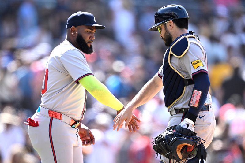 Jul 14, 2024; San Diego, California, USA; Atlanta Braves designated hitter Marcell Ozuna (left) and catcher Travis d'Arnaud (16) celebrate on the field after defeating the San Diego Padres at Petco Park. Mandatory Credit: Orlando Ramirez-USA TODAY Sports