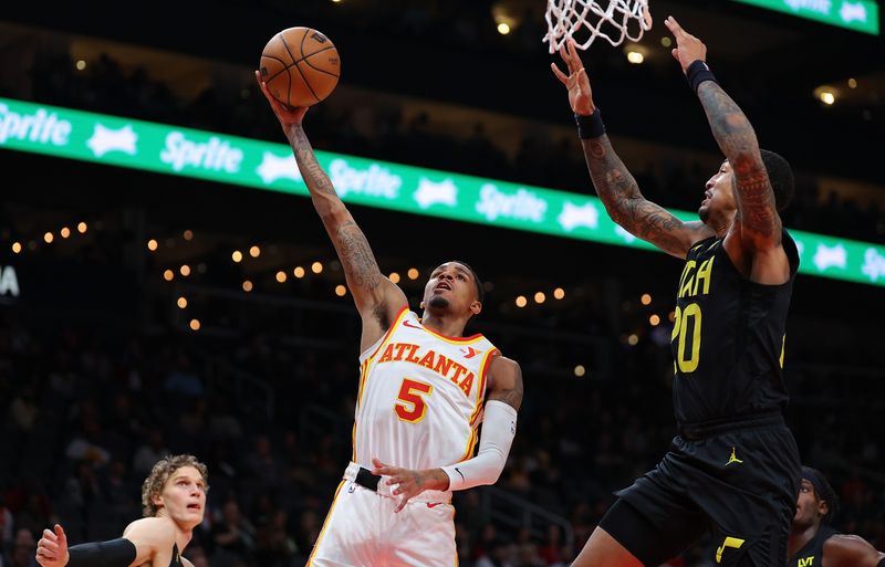 ATLANTA, GEORGIA - FEBRUARY 27:  Dejounte Murray #5 of the Atlanta Hawks drives against John Collins #20 of the Utah Jazz during the first quarter at State Farm Arena on February 27, 2024 in Atlanta, Georgia.  NOTE TO USER: User expressly acknowledges and agrees that, by downloading and/or using this photograph, user is consenting to the terms and conditions of the Getty Images License Agreement.  (Photo by Kevin C. Cox/Getty Images)