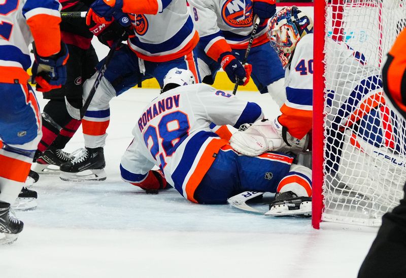 Apr 30, 2024; Raleigh, North Carolina, USA; New York Islanders defenseman Alexander Romanov (28) covers the puck in the crease against the Carolina Hurricanes during the first period in game five of the first round of the 2024 Stanley Cup Playoffs at PNC Arena. Mandatory Credit: James Guillory-USA TODAY Sports