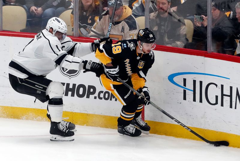 Feb 18, 2024; Pittsburgh, Pennsylvania, USA;  Pittsburgh Penguins right wing Reilly Smith (19) moves the puck ahead of Los Angeles Kings center Anze Kopitar (11) during the second period  at PPG Paints Arena. Los Angeles won 2-1. Mandatory Credit: Charles LeClaire-USA TODAY Sports