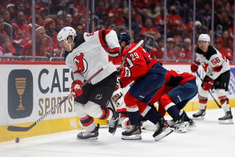 Nov 23, 2024; Washington, District of Columbia, USA; New Jersey Devils defenseman Johnathan Kovacevic (8) skates with the puck away from Washington Capitals center Hendrix Lapierre (29) in the third period at Capital One Arena. Mandatory Credit: Geoff Burke-Imagn Images