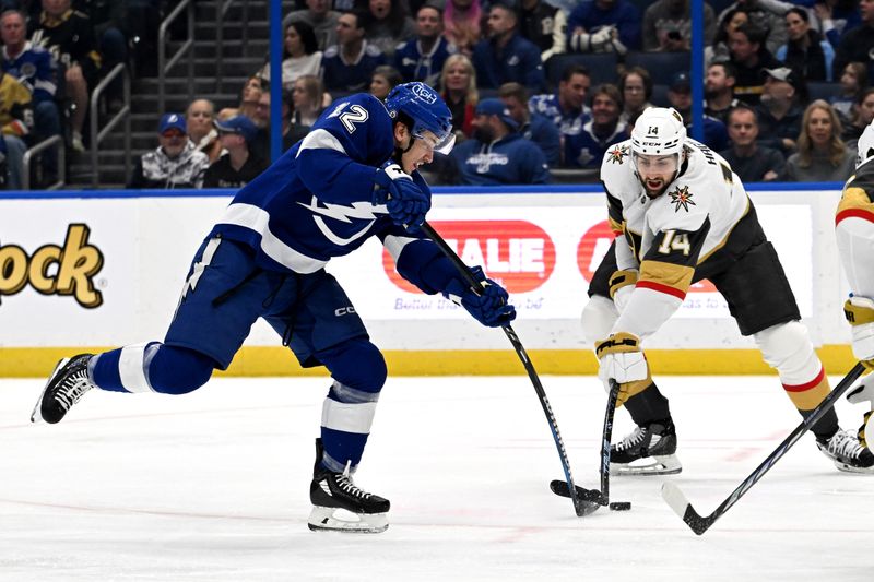 Dec 21, 2023; Tampa, Florida, USA; Tampa Bay Lightning center Alex Barre-Boulet (12) takes a shot past Las Vegas Golden Knights defensemen Nicholas Hague (14) in the first period at Amalie Arena. Mandatory Credit: Jonathan Dyer-USA TODAY Sports