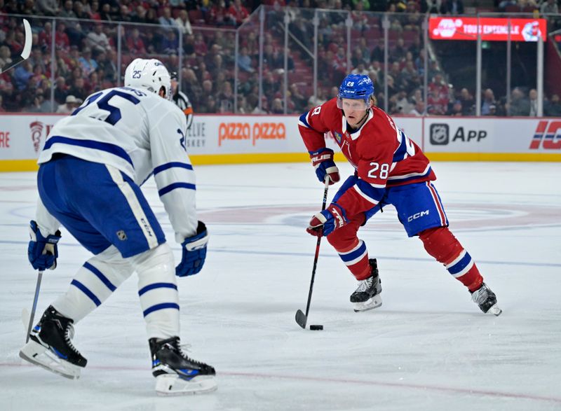 Oct 9, 2024; Montreal, Quebec, CAN; Montreal Canadiens forward Christian Dvorak (28) plays the puck against Toronto Maple Leafs defenseman Conor Timmins (25) during the second period at the Bell Centre. Mandatory Credit: Eric Bolte-Imagn Images