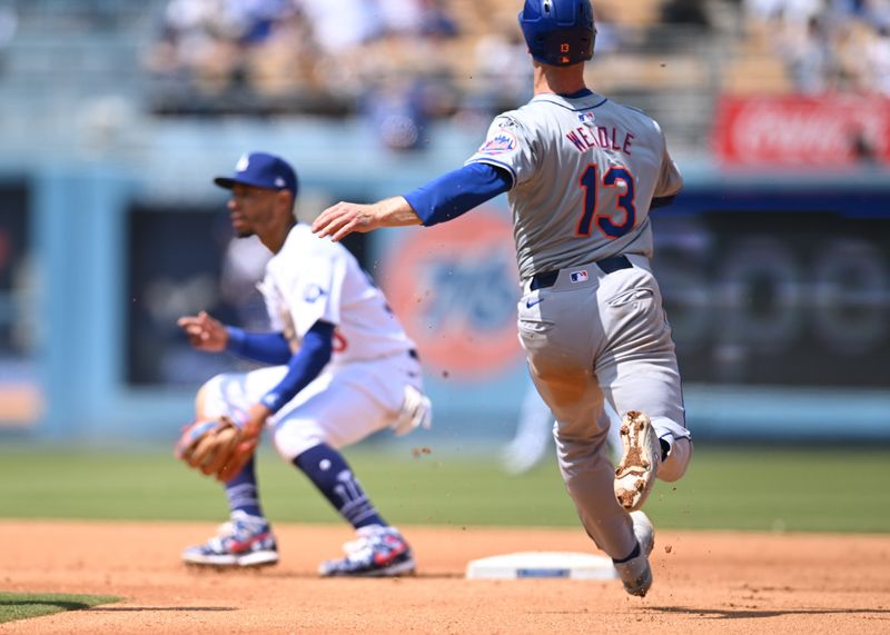 Apr 20, 2024; Los Angeles, California, USA; New York Mets third baseman Joey Wendle (13) steals second base against Los Angeles Dodgers shortstop Mookie Betts (50) during the fourth inning at Dodger Stadium. Mandatory Credit: Jonathan Hui-USA TODAY Sports