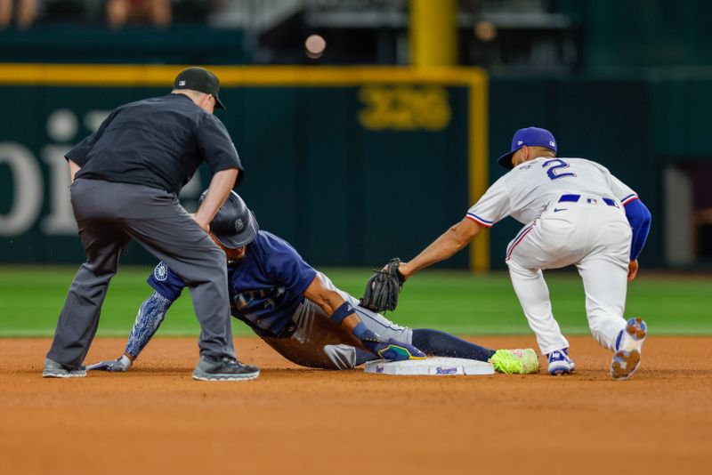 Sep 21, 2024; Arlington, Texas, USA; Seattle Mariners outfielder Julio Rodríguez (44) slides in under the tag of Texas Rangers second base Marcus Semien (2) during the fourth inning at Globe Life Field. Mandatory Credit: Andrew Dieb-Imagn Images