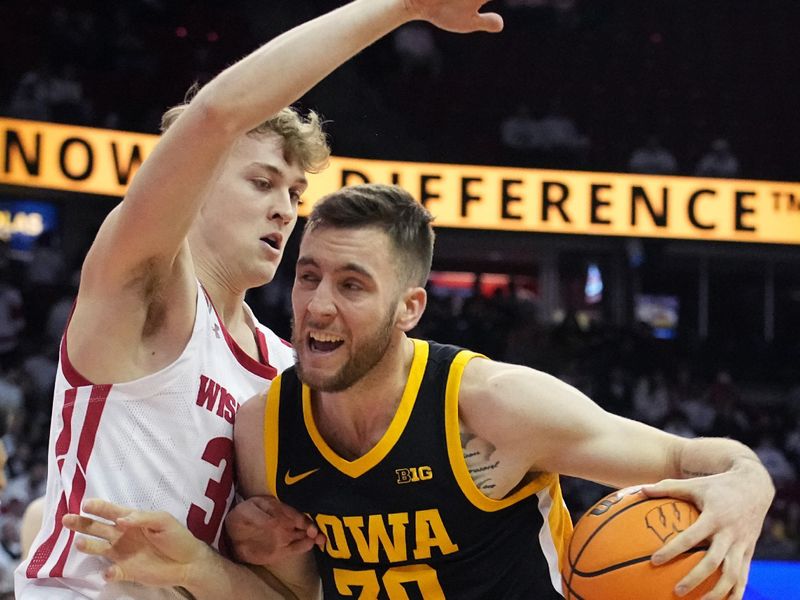 Feb 22, 2023; Madison, Wisconsin, USA; Iowa guard Connor McCaffery (30) tries to get past Wisconsin forward Markus Ilver (35) during the first half at Kohl Center. Mandatory Credit: Mark Hoffman-USA TODAY Sports