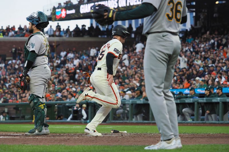 Jul 31, 2024; San Francisco, California, USA; San Francisco Giants right fielder Mike Yastrzemski (5) scores a run between Oakland Athletics catcher Shea Langeliers (23) and starting pitcher Ross Stripling (36) during the fifth inning at Oracle Park. Mandatory Credit: Kelley L Cox-USA TODAY Sports