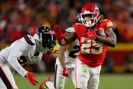 Kansas City Chiefs running back Kareem Hunt (29) fends off Houston Texans safety Calen Bullock (21) during the second half of an NFL football divisional playoff game, Saturday, Jan. 18, 2025 in Kansas City, Mo. The Chiefs defeated the Texans by a score of 23-14. (AP Photo/Reed Hoffmann)