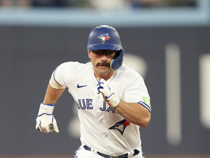 Sep 8, 2023; Toronto, Ontario, CAN; Toronto Blue Jays designated hitter Davis Schneider (36) runs to third base on a ground ball hit by second baseman Whit Merrifield (not pictured) against the Kansas City Royals during the second inning at Rogers Centre. Mandatory Credit: John E. Sokolowski-USA TODAY Sports