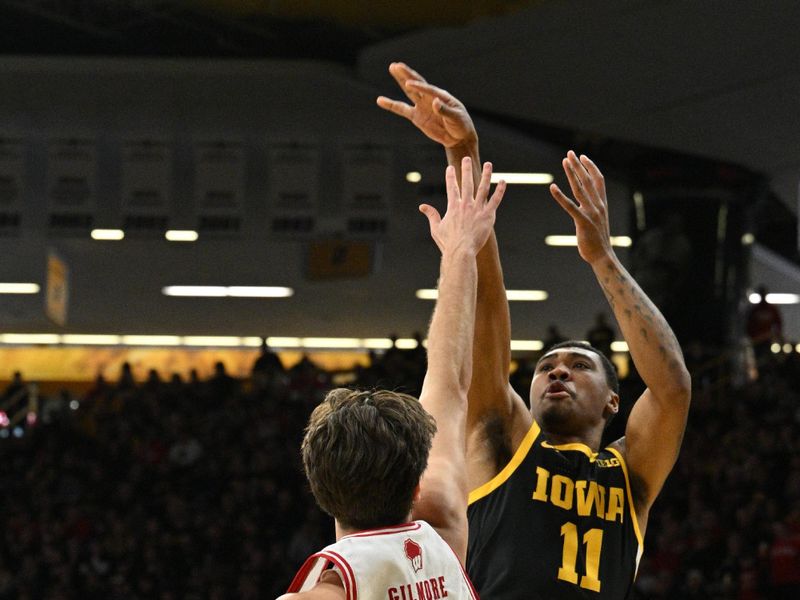 Feb 17, 2024; Iowa City, Iowa, USA; Iowa Hawkeyes guard Tony Perkins (11) shoots the ball over Wisconsin Badgers forward Carter Gilmore (14) during the second half at Carver-Hawkeye Arena. Mandatory Credit: Jeffrey Becker-USA TODAY Sports