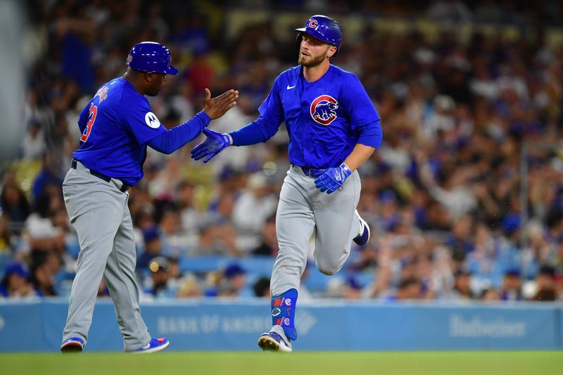 Sep 9, 2024; Los Angeles, California, USA; Chicago Cubs first baseman Michael Busch (29) is greeted by third base coach Willie Harris (33) after hitting a solo home run against the Los Angeles Dodgers during the fourth inning at Dodger Stadium. Mandatory Credit: Gary A. Vasquez-Imagn Images