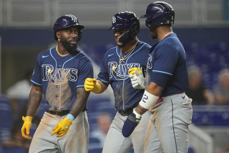 Aug 29, 2023; Miami, Florida, USA;  Tampa Bay Rays third baseman Isaac Paredes, center, celebrates his three-run home run in the ninth inning against the Miami Marlins with left fielder Randy Arozarena, left, and first baseman Yandy Diaz (2) at loanDepot Park. Mandatory Credit: Jim Rassol-USA TODAY Sports