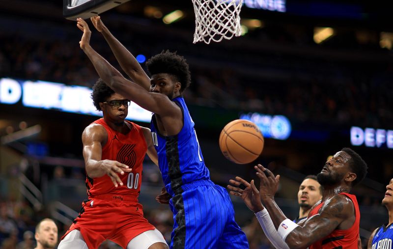 ORLANDO, FLORIDA - APRIL 01: Scoot Henderson #00 of the Portland Trail Blazers passes around Jonathan Isaac #1 of the Orlando Magic during a game  at Kia Center on April 01, 2024 in Orlando, Florida. NOTE TO USER: User expressly acknowledges and agrees that, by downloading and or using this photograph, User is consenting to the terms and conditions of the Getty Images License Agreement. (Photo by Mike Ehrmann/Getty Images)