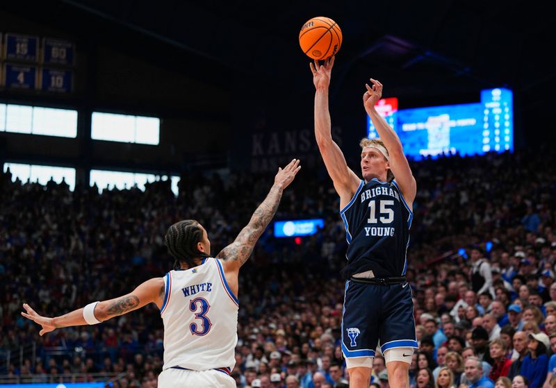 Jan 31, 2026; Lawrence, Kansas, USA; BYU Cougars guard Richie Saunders (15) shoots against Kansas Jayhawks guard Tre White (3) during the first half at Allen Fieldhouse. Mandatory Credit: Jay Biggerstaff-Imagn Images