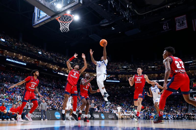 Mar 17, 2023; Columbus, OH, USA; Memphis Tigers guard Kendric Davis (3) goes to the basket defended by Florida Atlantic Owls guard Nicholas Boyd (2) and guard Johnell Davis (1) in the first half at Nationwide Arena. Mandatory Credit: Rick Osentoski-USA TODAY Sports