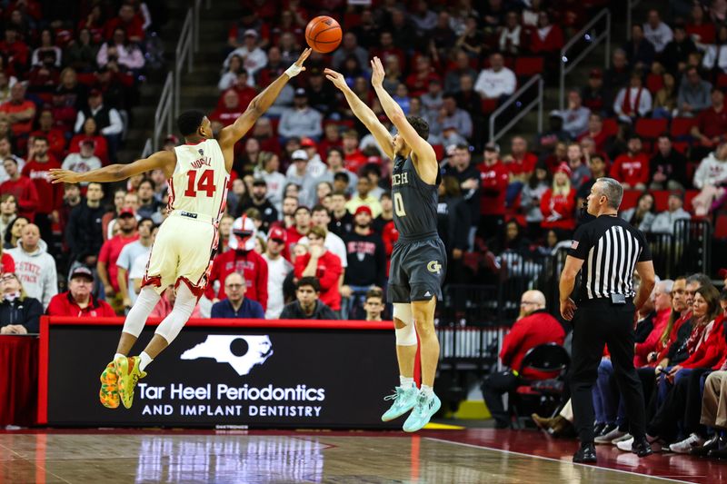 Feb 4, 2023; Raleigh, North Carolina, USA; Georgia Tech Yellow Jackets guard Lance Terry (0) shoots a three point basket defended by North Carolina State Wolfpack guard Casey Morsell (14) during the first half a at PNC Arena. Mandatory Credit: Jaylynn Nash-USA TODAY Sports