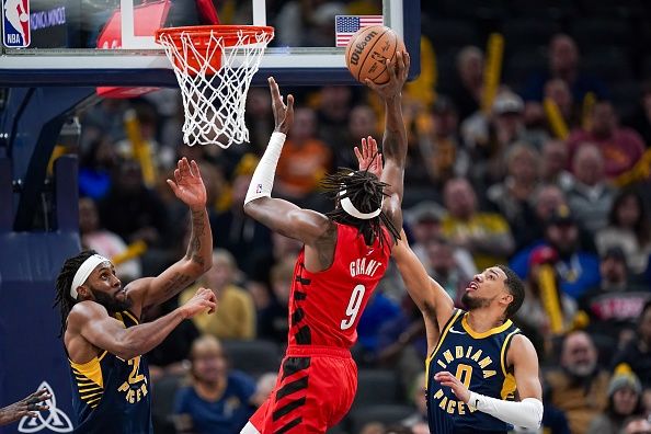 INDIANAPOLIS, INDIANA - NOVEMBER 27: Jerami Grant #9 of the Portland Trail Blazers attempts a shot while being guarded by Isaiah Jackson #22 and Tyrese Haliburton #0 of the Indiana Pacers in the fourth quarter at Gainbridge Fieldhouse on November 27, 2023 in Indianapolis, Indiana. NOTE TO USER: User expressly acknowledges and agrees that, by downloading and or using this photograph, User is consenting to the terms and conditions of the Getty Images License Agreement. (Photo by Dylan Buell/Getty Images)