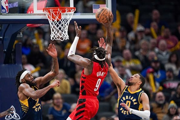 INDIANAPOLIS, INDIANA - NOVEMBER 27: Jerami Grant #9 of the Portland Trail Blazers attempts a shot while being guarded by Isaiah Jackson #22 and Tyrese Haliburton #0 of the Indiana Pacers in the fourth quarter at Gainbridge Fieldhouse on November 27, 2023 in Indianapolis, Indiana. NOTE TO USER: User expressly acknowledges and agrees that, by downloading and or using this photograph, User is consenting to the terms and conditions of the Getty Images License Agreement. (Photo by Dylan Buell/Getty Images)