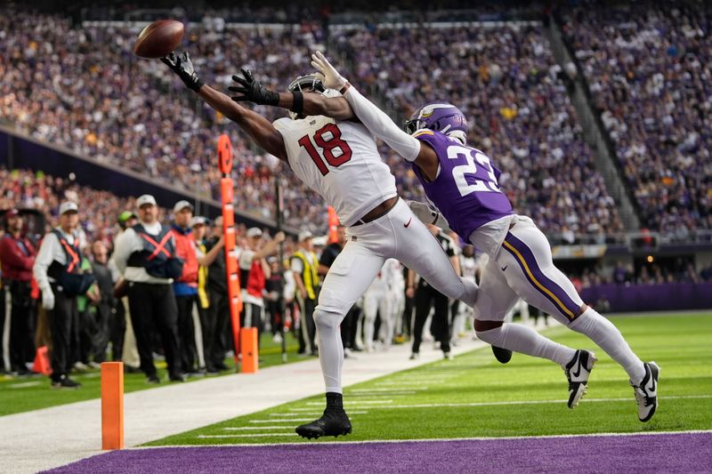 Arizona Cardinals wide receiver Marvin Harrison Jr. (18) reaches for an incomplete pass over Minnesota Vikings cornerback Fabian Moreau (23) during the first half of an NFL football game Sunday, Dec. 1, 2024, in Minneapolis. (AP Photo/Abbie Parr)