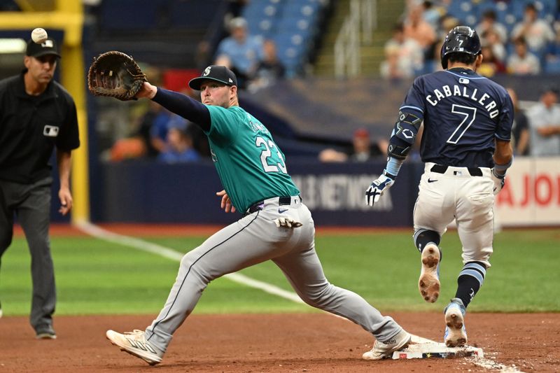 Jun 26, 2024; St. Petersburg, Florida, USA; Tampa Bay Rays short stop Jose Caballero (7) beats out a bunt as Seattle Mariners first baseman Ty France (23) waits for the ball in the fifth inning at Tropicana Field. Mandatory Credit: Jonathan Dyer-USA TODAY Sports