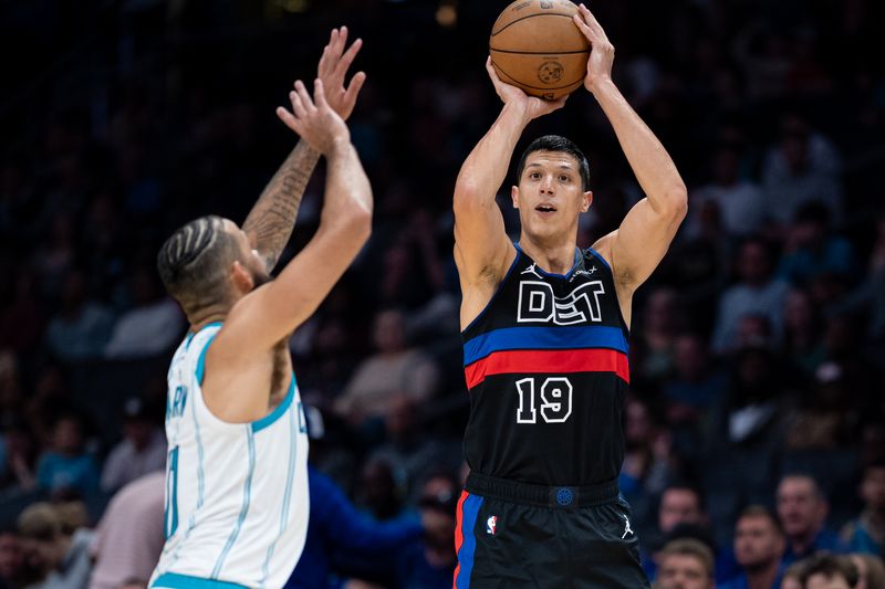 CHARLOTTE, NORTH CAROLINA - NOVEMBER 06: Simone Fontecchio #19 of the Detroit Pistons shoots the ball while guarded by Cody Martin #11 of the Charlotte Hornets in the fourth quarter during their game at Spectrum Center on November 06, 2024 in Charlotte, North Carolina. NOTE TO USER: User expressly acknowledges and agrees that, by downloading and or using this photograph, User is consenting to the terms and conditions of the Getty Images License Agreement. (Photo by Jacob Kupferman/Getty Images)