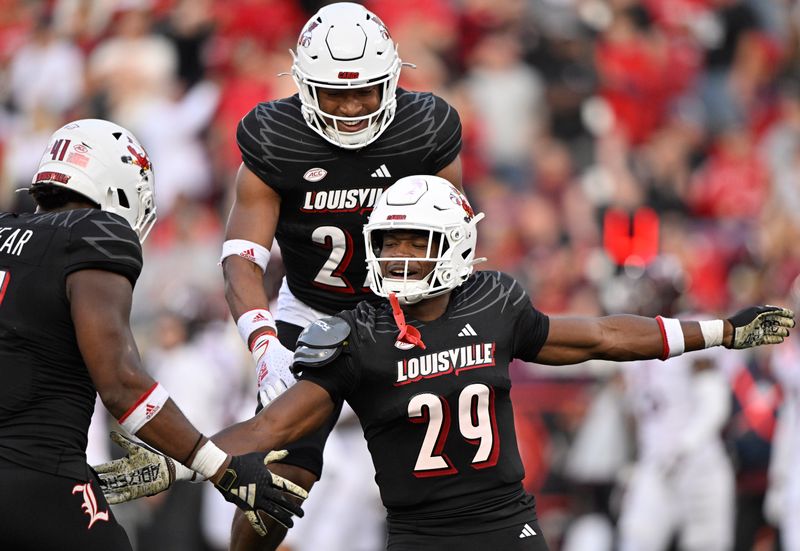 Nov 4, 2023; Louisville, Kentucky, USA;  Louisville Cardinals defensive back Storm Duck (29) celebrates with defensive lineman Ramon Puryear (41) and defensive back Devin Neal (27) during the second half against the Virginia Tech Hokies at L&N Federal Credit Union Stadium. Louisville defeated Virginia Tech 34-3. Mandatory Credit: Jamie Rhodes-USA TODAY Sports