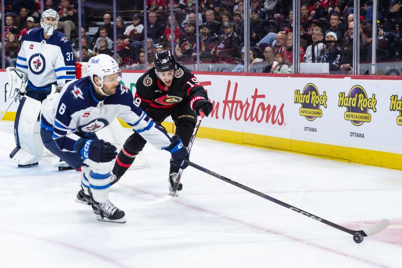 Feb 26, 2025; Ottawa, Ontario, CAN; Winnipeg Jets defenseman Colin Miller (6) and Ottawa Senators right wing Drake Batherson (19) battle for control of the puck in the first period at the Canadian Tire Centre. Mandatory Credit: Marc DesRosiers-Imagn Images