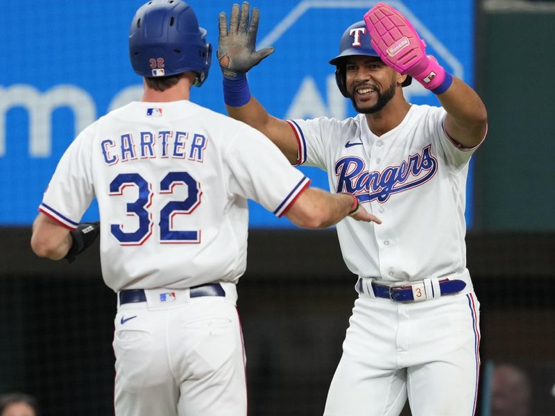 Sep 20, 2023; Arlington, Texas, USA; Texas Rangers center fielder Evan Carter (32) celebrates scoring with center fielder Leody Taveras (3) against the Boston Red Sox during the second inning at Globe Life Field. Mandatory Credit: Jim Cowsert-USA TODAY Sports